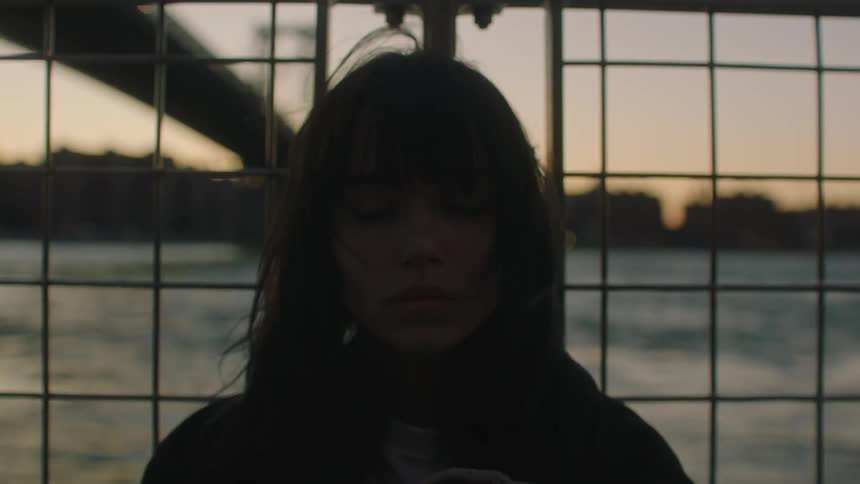 A girl sitting facing the sea in the city