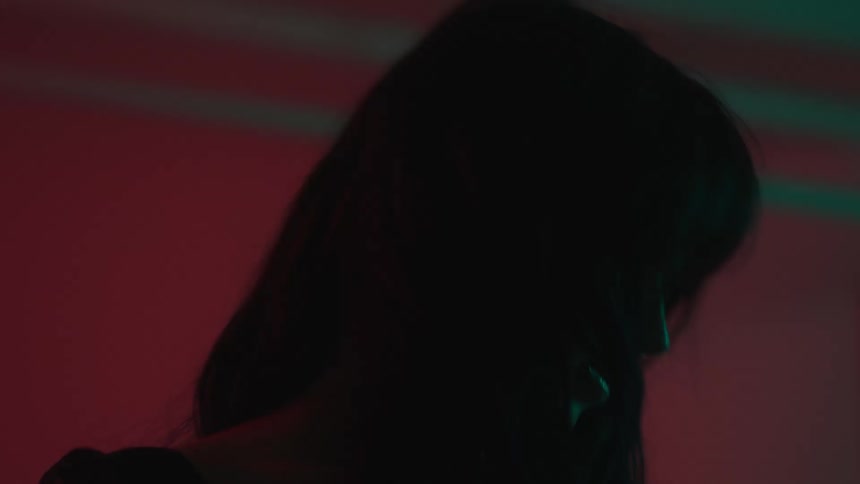 Portrait of a woman dancing in an indoor setting with reflections of lights
