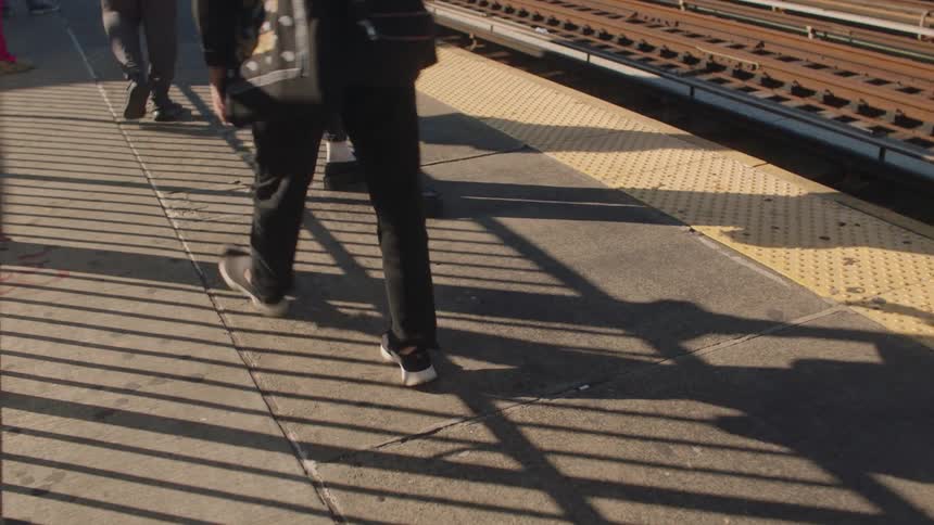 Pedestrians walk on the train station platform