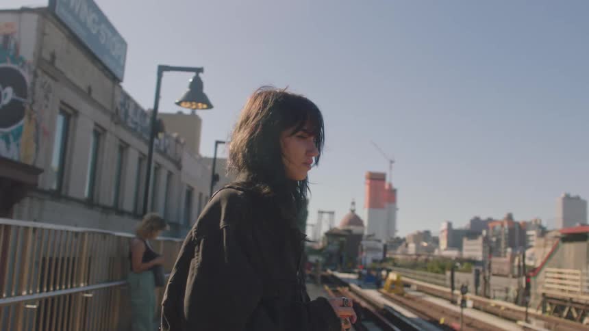 Woman with a discouraged facial expression facing a train station