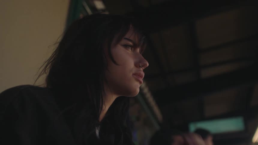 A serious young woman sitting in a train station