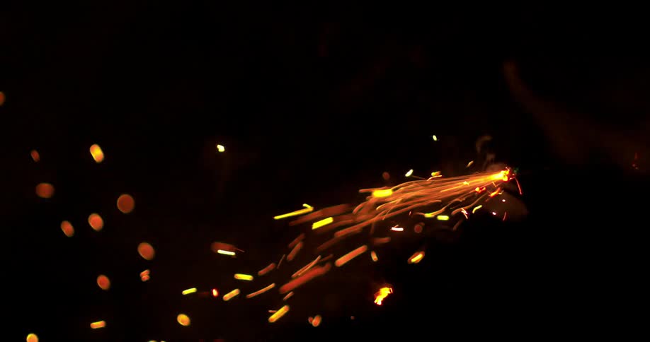 A person lights a fuse in a dark room