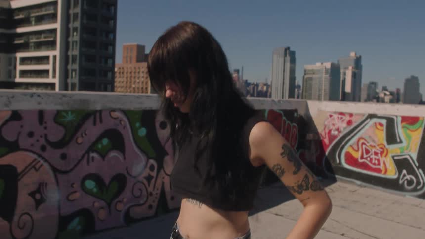 Portrait of a young woman walking on the terrace of a building in daylight
