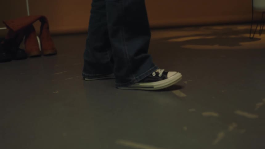 A person wearing jeans and all stars shoes