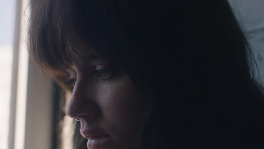 A woman wiping tears from her eyes