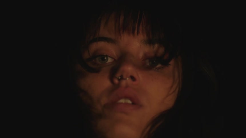 Closeup of a scared womans face at night