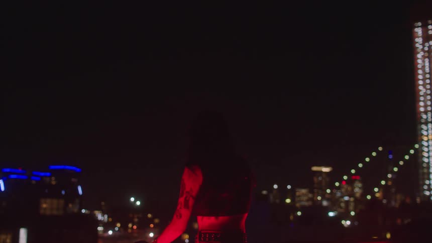 Woman on red light in front of the city at night