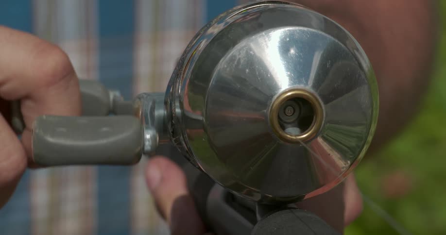 A man is reeling in a fishing pole