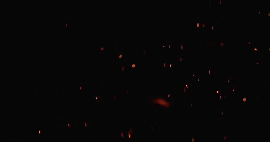 Flames and embers fly through the dark night air