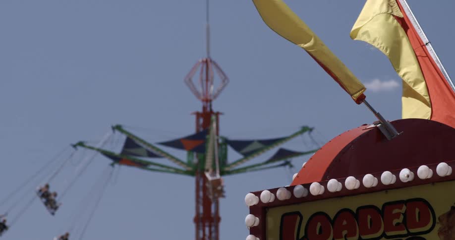 Carnival rides are full of people on a clear day
