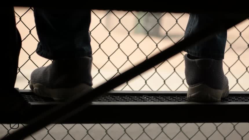 A person's feet rest on a bleacher seat