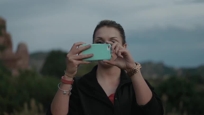 Woman snaps a picture outside using a smartphone