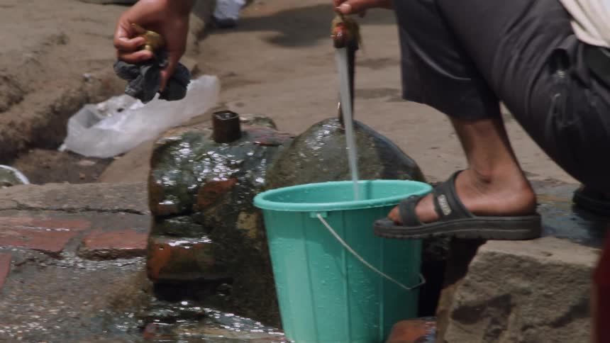 A man is filling a bucket with water
