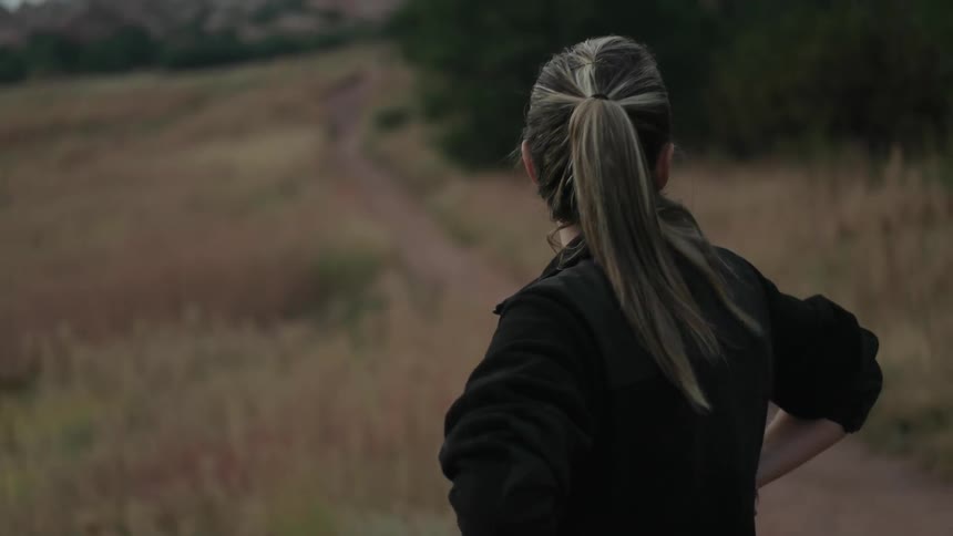 A woman is taking in the view of a large field