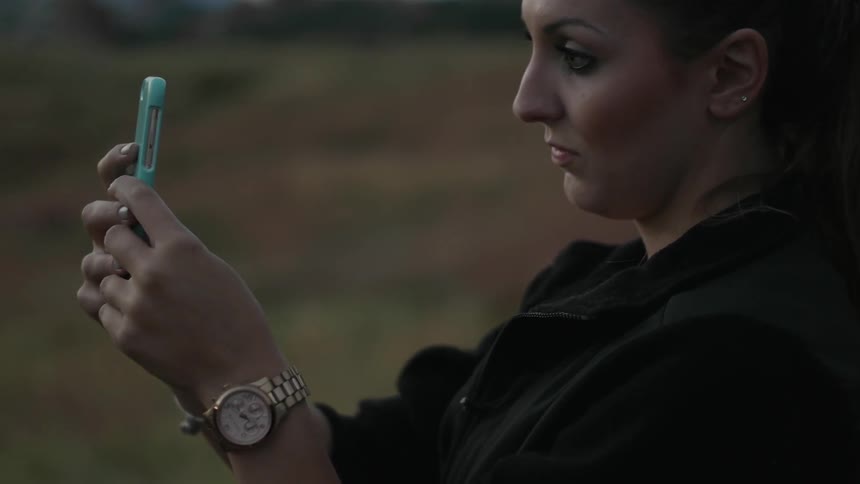 A woman is taking photographs with her phone