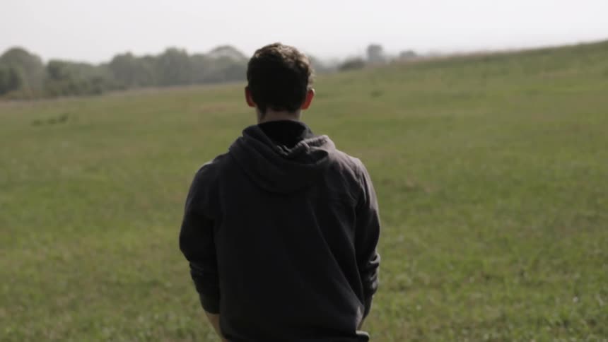 Man throws a ball for a dog to fetch in a grassy field
