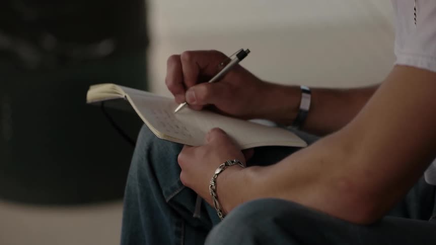 A man is writing in a notebook