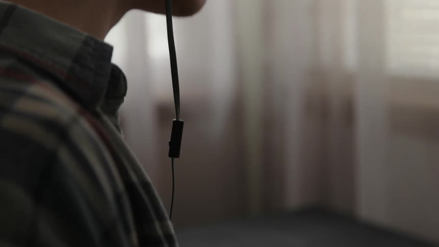 A man is wearing headphones and using a tablet