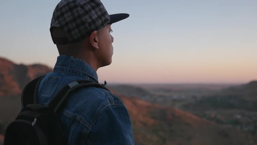 Man looks out towards the horizon at sunset