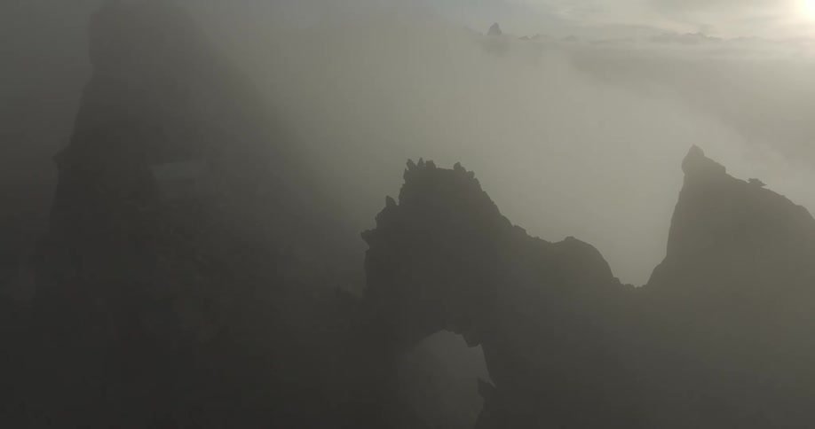 Aerial of rocky mountain covered by fog