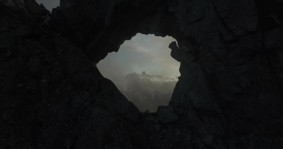 Aerial view of a hole in the midst of a mountain on a cliff on a morning day
