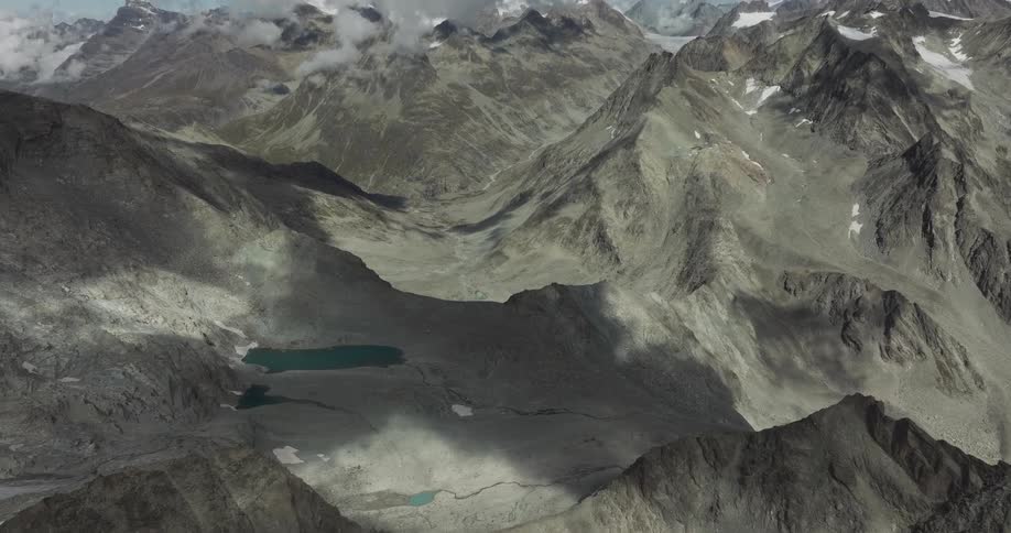 Panorama of peaks and mountains with remnants of snow in daylight