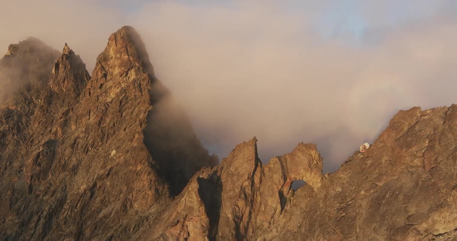 Clouds are sitting on the peak of the mountain