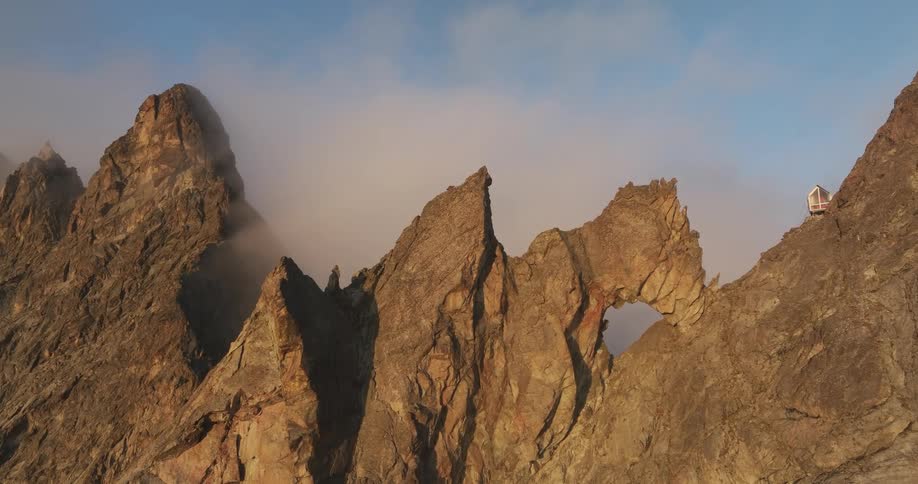 A cabin on top of a rocky mountain in the morning