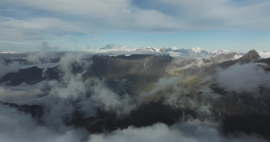 A mountain range is partially occluded by patches of thick fog