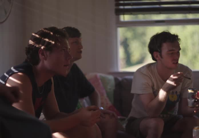 Four friends sit on the couch watching something and then show disappointment