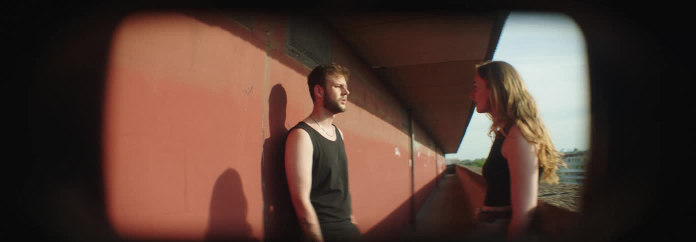 A couple arguing on the balcony of a building
