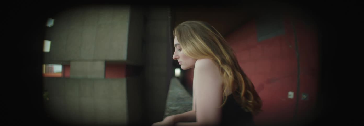 Young blonde woman on the balcony of a building lost in thought