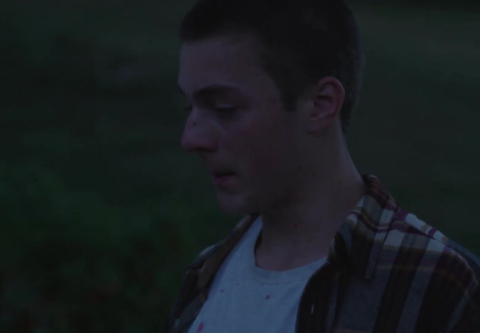 Man passing in front of another who is taking a deep breath with a facial expression of weakness
