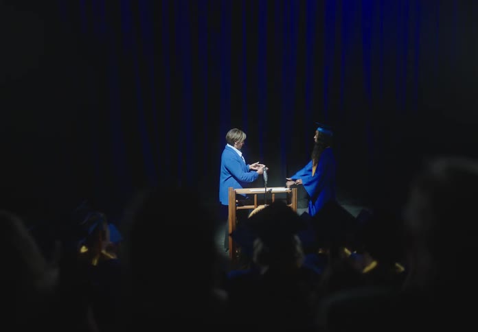 Speaker greets a graduate student at the stage