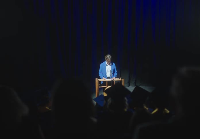 Woman walks to the podium to give speech to the graduating students
