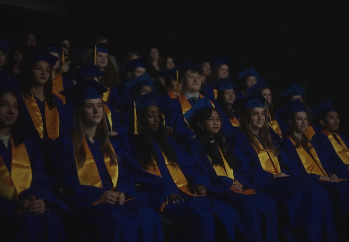 The spot light shines on a graduate in the crowd