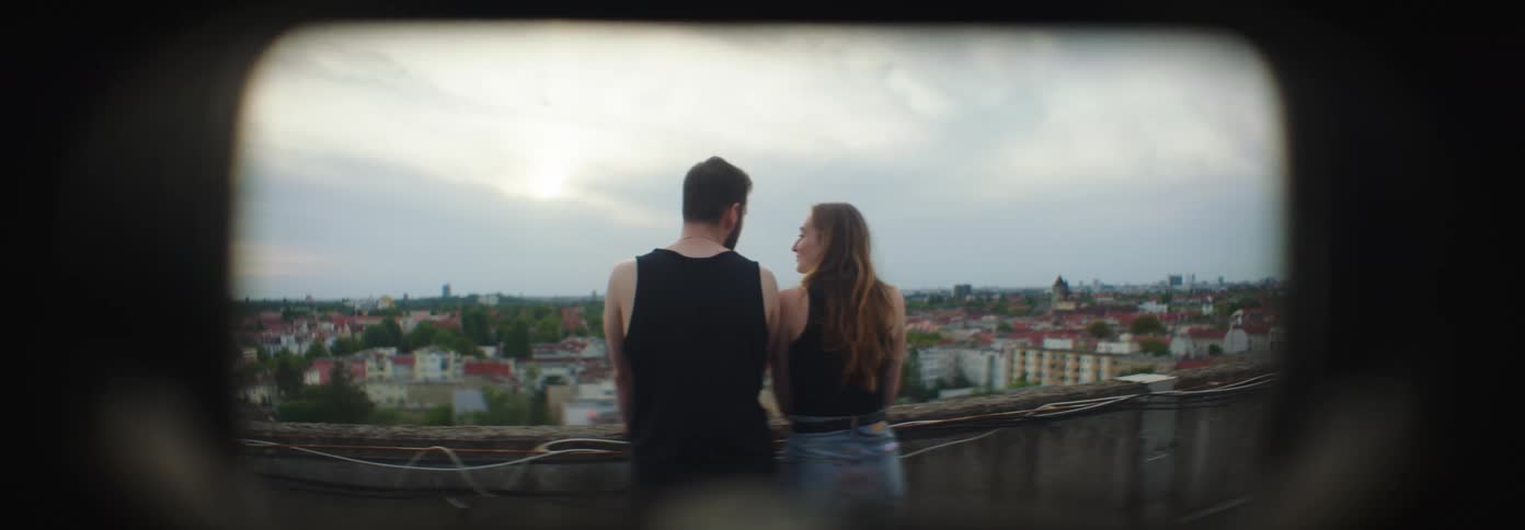 A man and woman stand on the roof top together