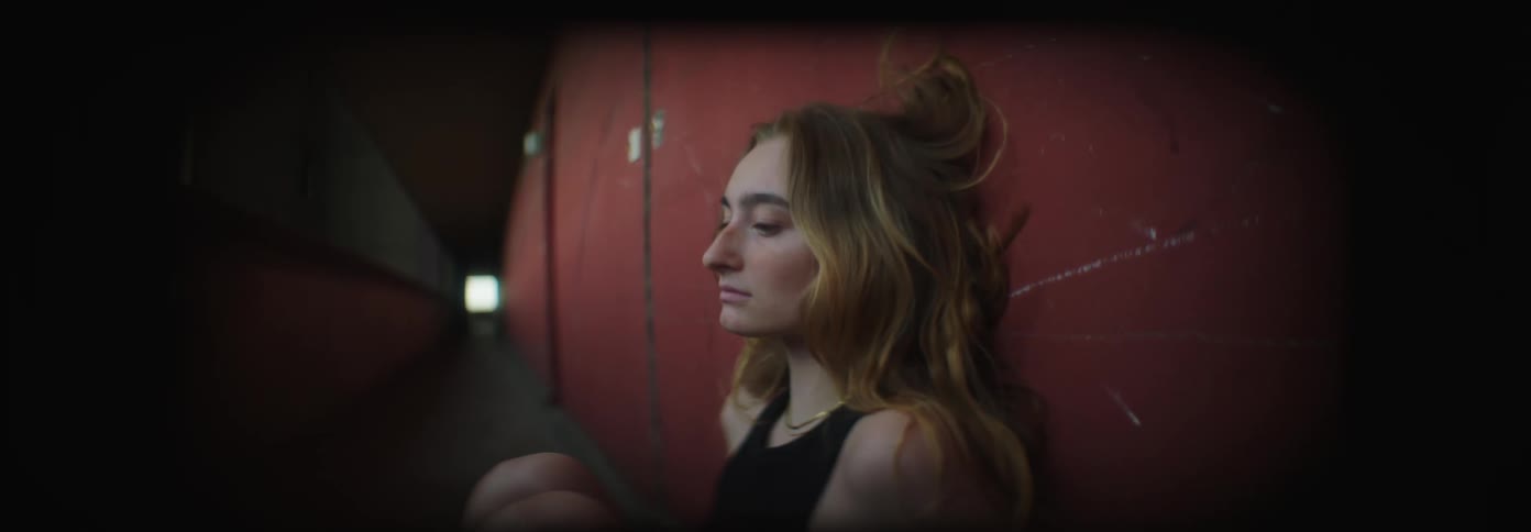Woman throwing herself against the wall of a corridor and sitting down in a disheartened manner