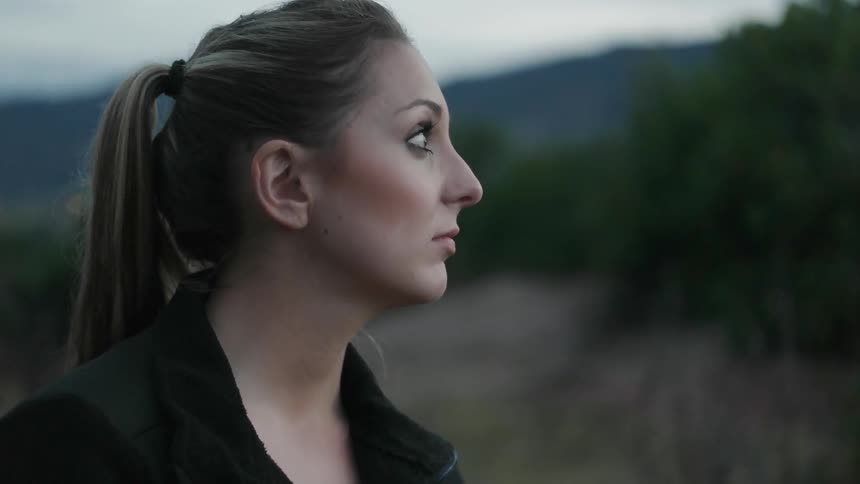 A woman stands in a rural area