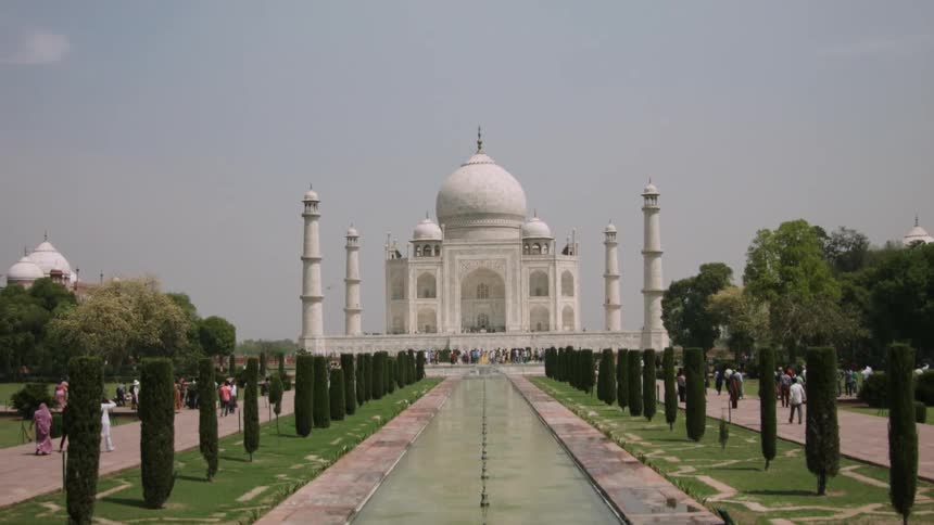 A pool of water extends in front the Taj Mahal