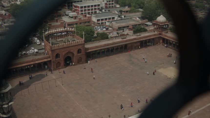 People walk in a large building courtyard