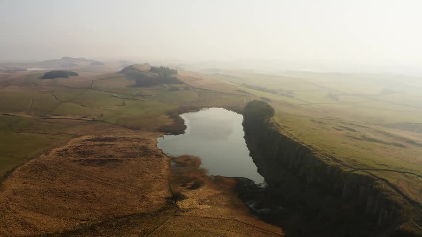 Lake in a field under the morning mist