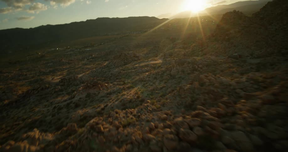 Stones forming peaks of mountains with the sun on the horizon