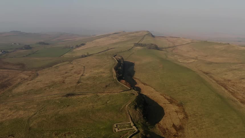Arial view of hadrians wall across a hilly landscape on a foggy day