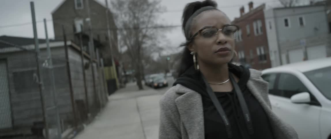 A woman is walking on the sidewalk on a cloudy day
