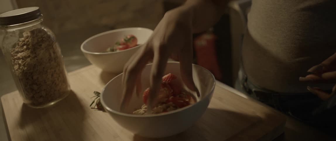 Woman mixes a bowl of food with her hand