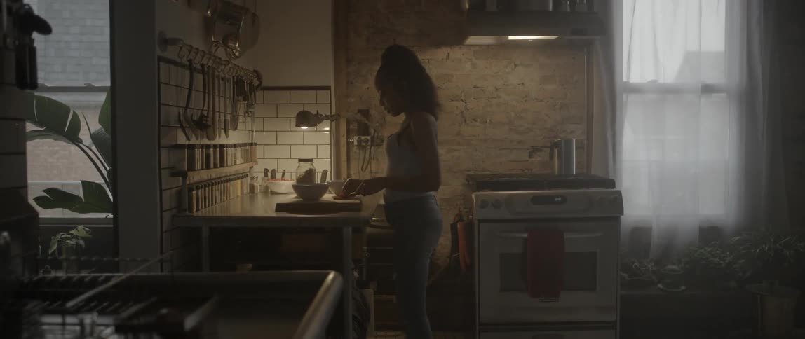 A woman is cutting food in a kitchen