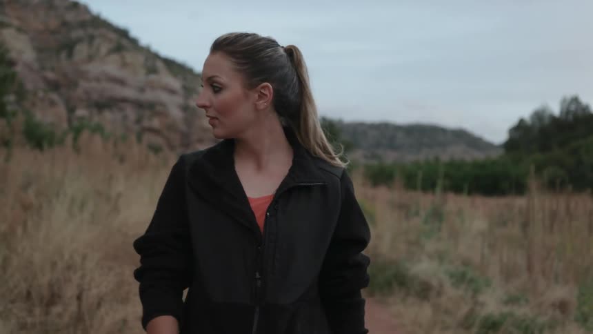 A woman walks in and looks around a rural area