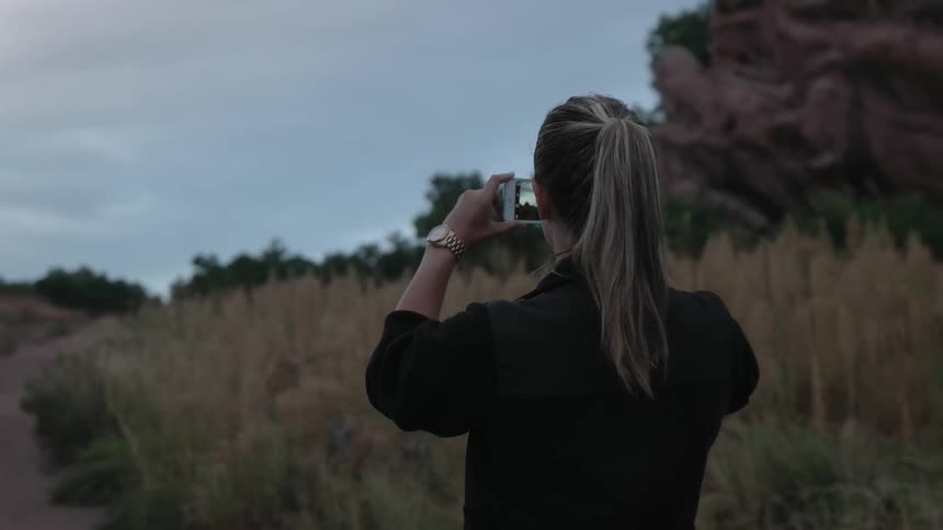 A woman pulls out her phone to take a picture