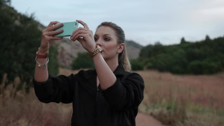 A woman takes a picture with her phone